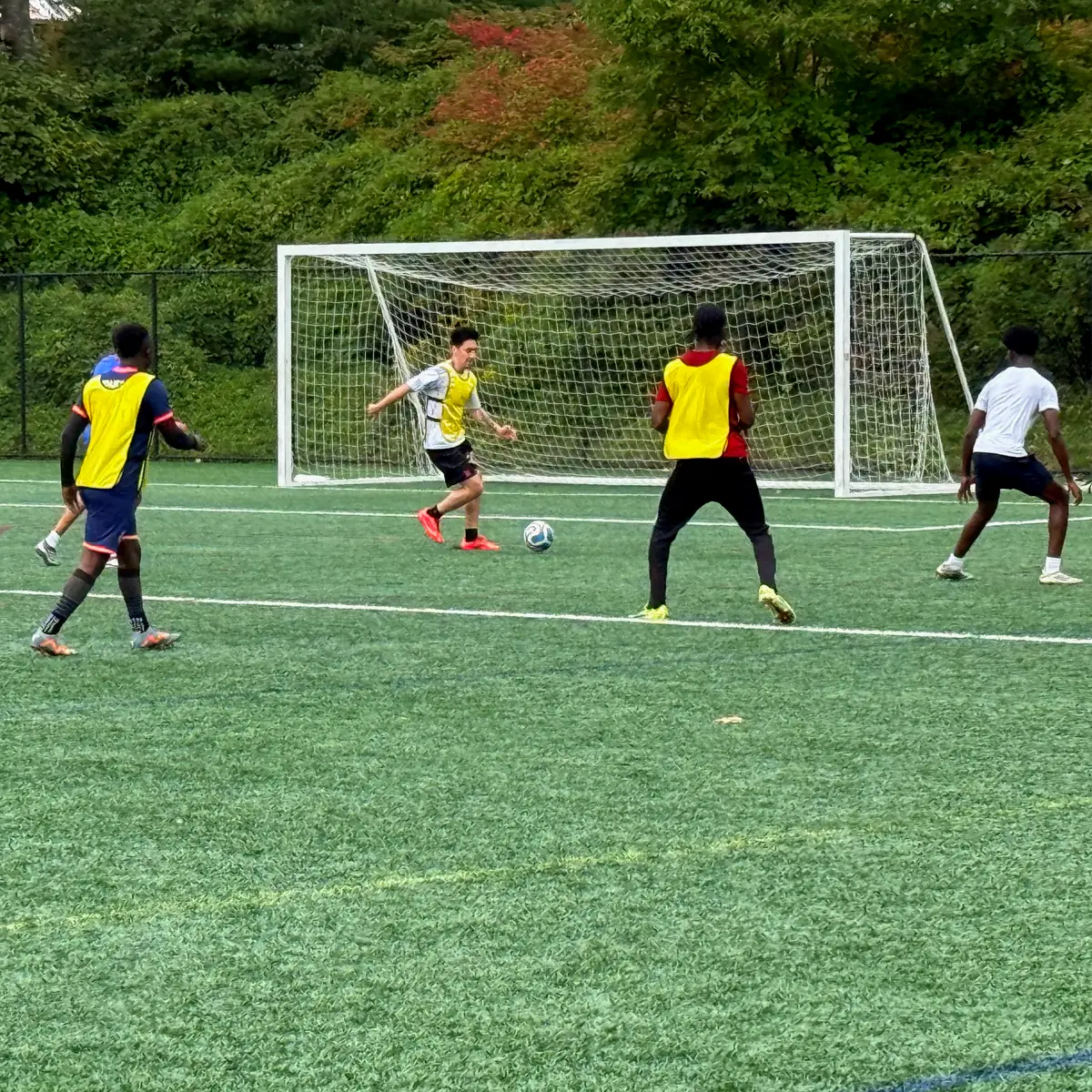 Princeton Soccer Group players contesting the ball in front of a goal during a pickup game